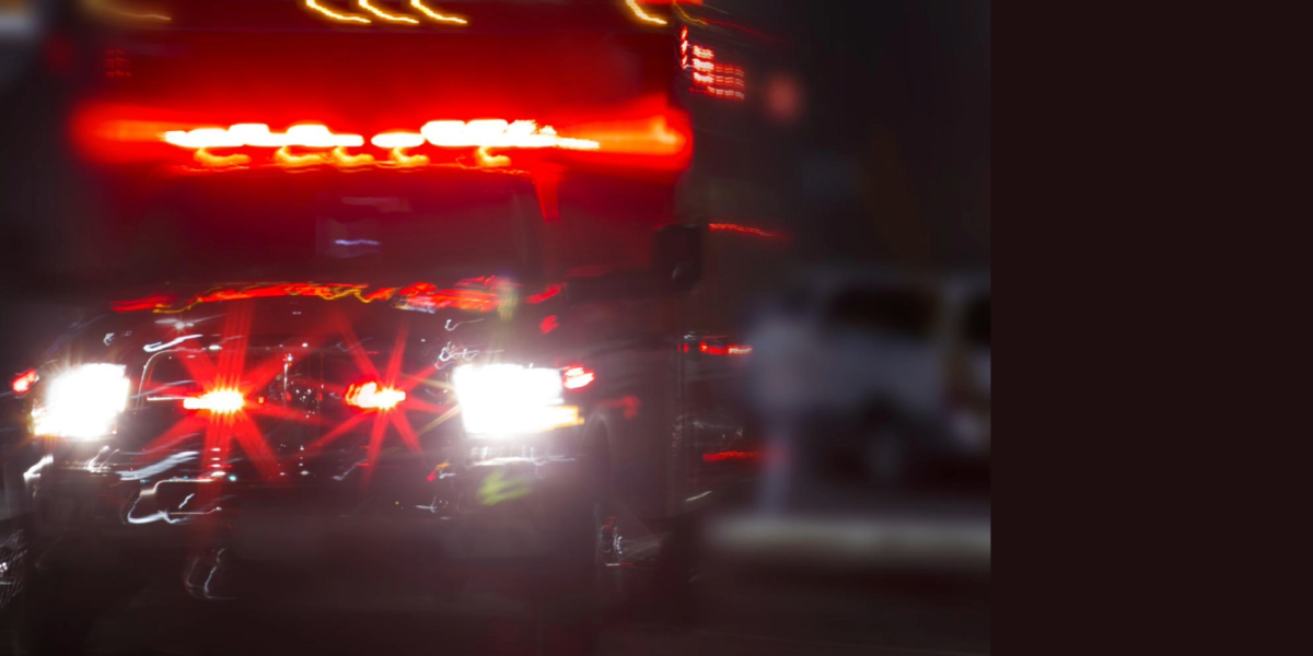blurred out photo of an ambulance with its lights flashing