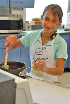A girl stirring a pot.