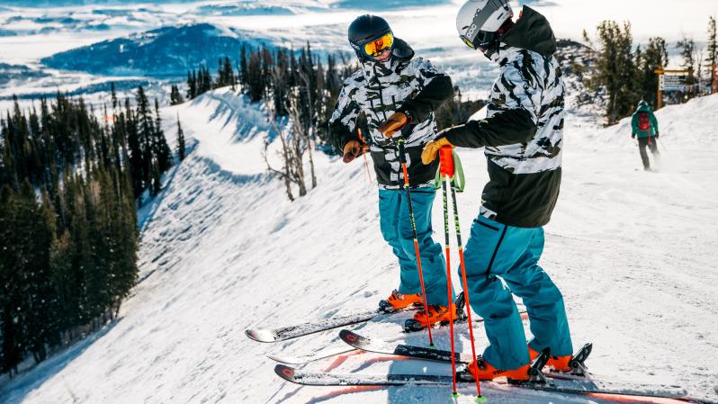 Skier instructing another skier on a snowy mountain