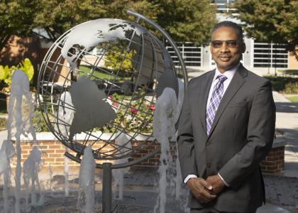 Professor Roderick Lee stands near globe fountain at Penn State Harrisburg