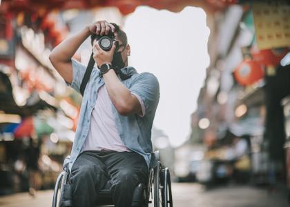 Man in wheelchair taking a photograph
