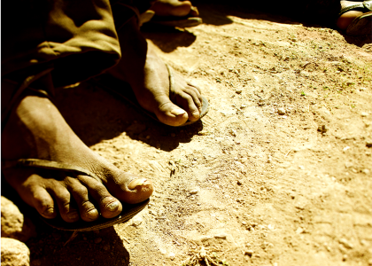 Indigenous children's' feet standing in dirt