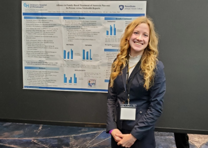 Chloe Connor stands in front of a research poster as an undergraduate student at Penn State.