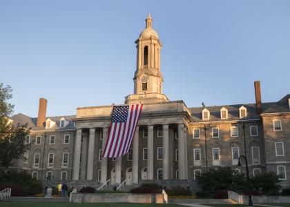 wide shot old main with flag