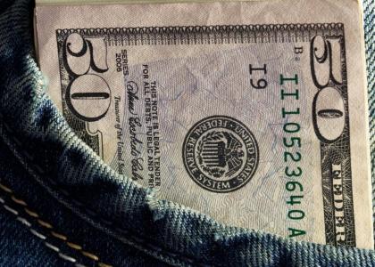 folded 50 dollar bills in jeans pocket
