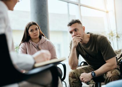 Military couple sitting with therapist