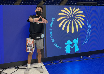 Jacob Santos setting up for THON weekend, doing the diamond hand sign, and wearing shorts and a mask. 