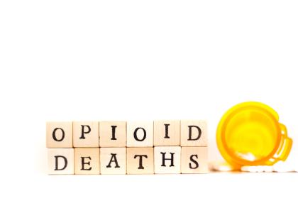 The words "Opioid deaths" written in wooden tiles