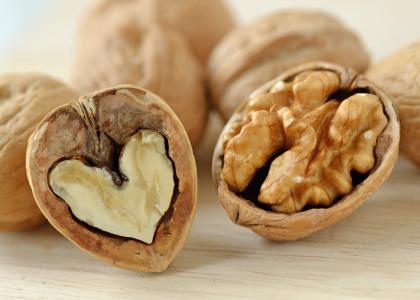 A cross-section of a walnut next to a half of a walnut
