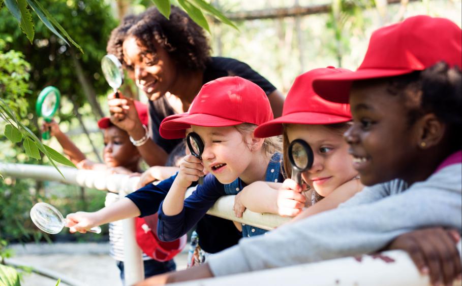Kids with magnifying glasses wearing red hats