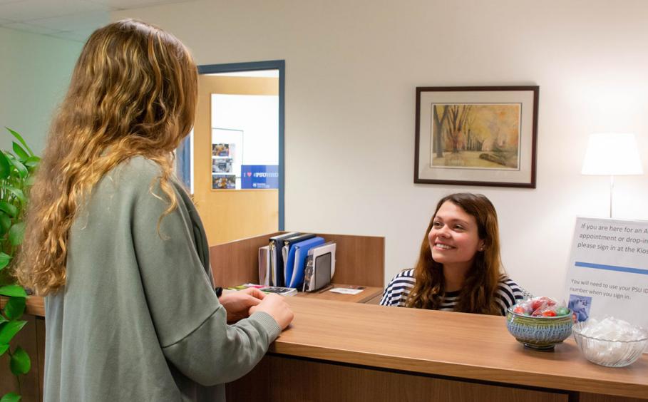 Student at the font desk of the office for Student Advising and Engagement