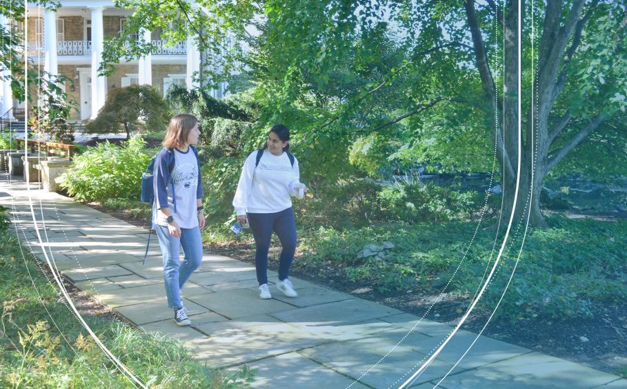 Students talking while walking near the alumni center