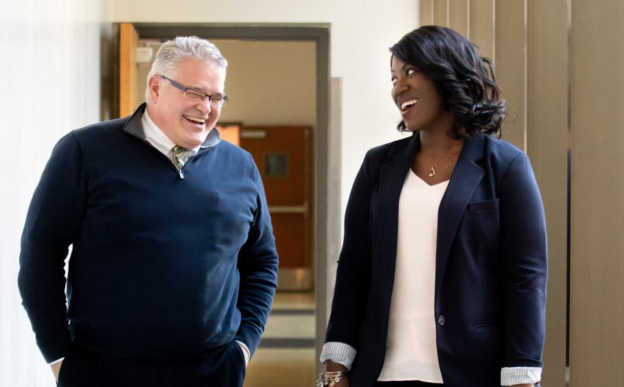 Health care administrators walking through a hallway towards the camera.