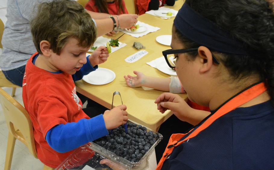 Students introducing children to different fruits and vegetables. 