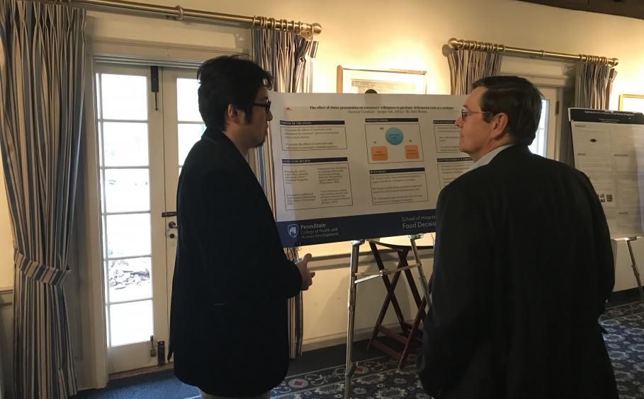 Graduate student presenting research during a poster session.
