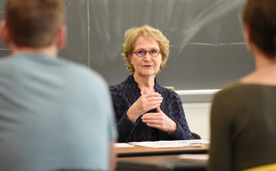 Professor speaking with students in a classroom