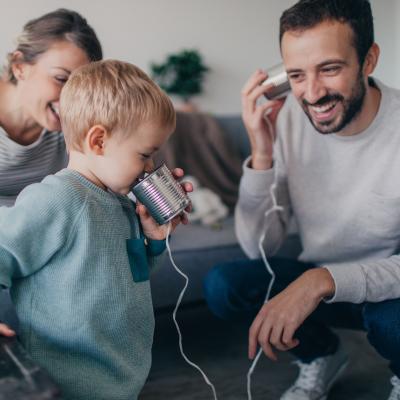 Child with toy phone talking to an adult male