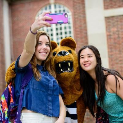 Students taking selfie with Nittany Lion