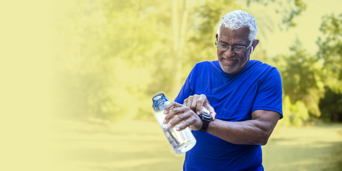 Older man holding water bottle and looking at watch