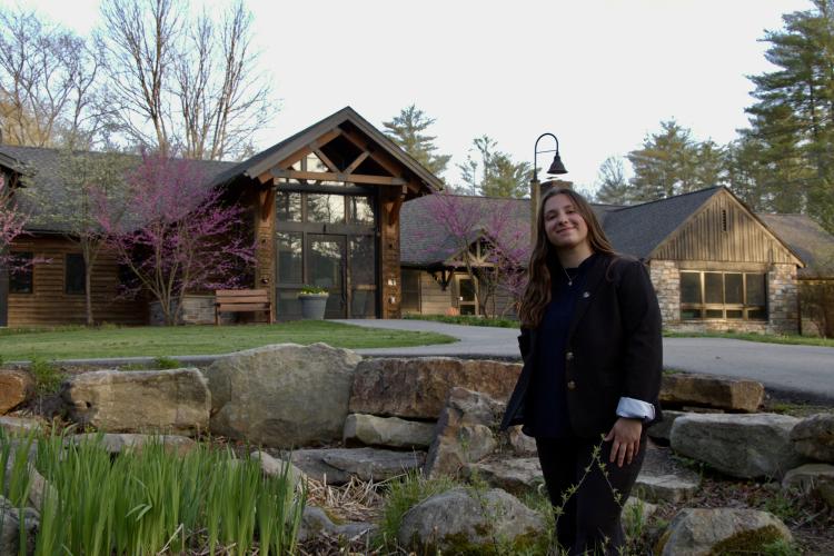 Amy standing in front of a cabin building