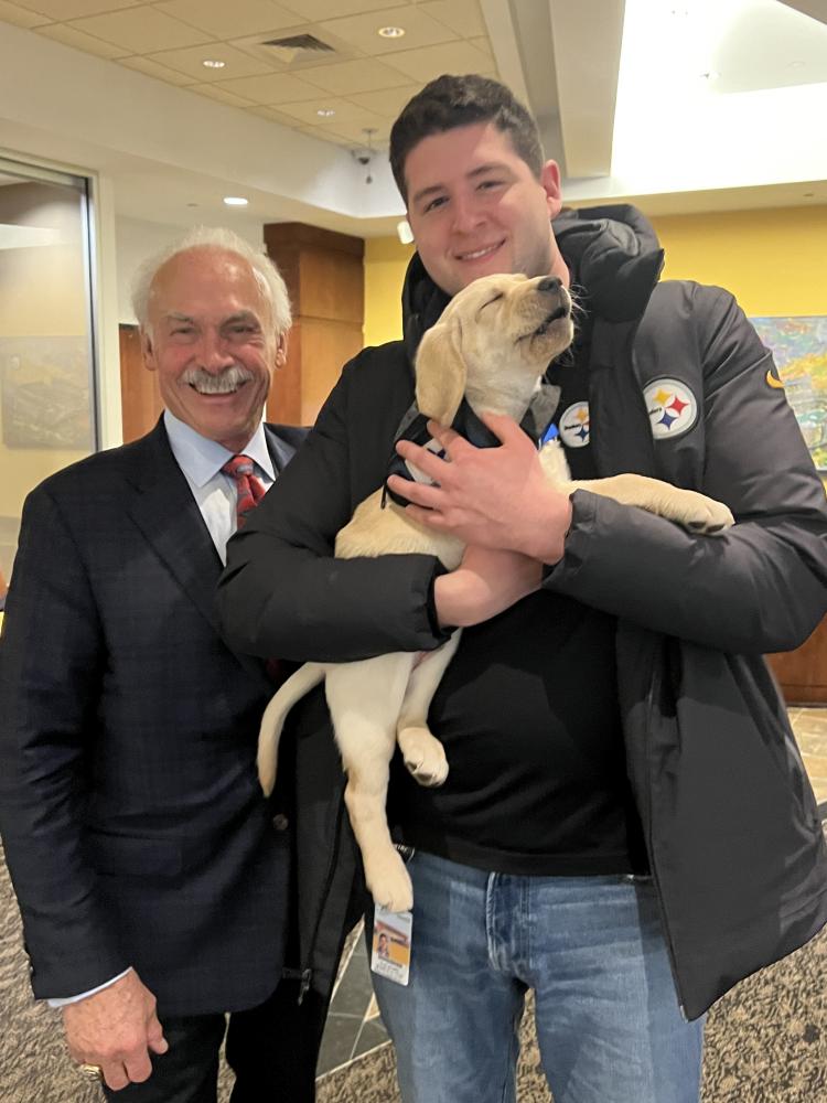 Fernandez with Rocky Bleier and a puppy