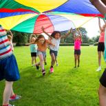 Children playing under parachute
