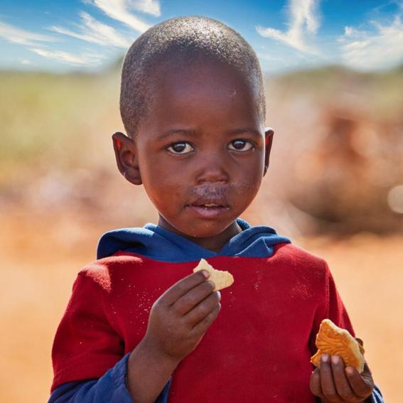 small African boy eating outside